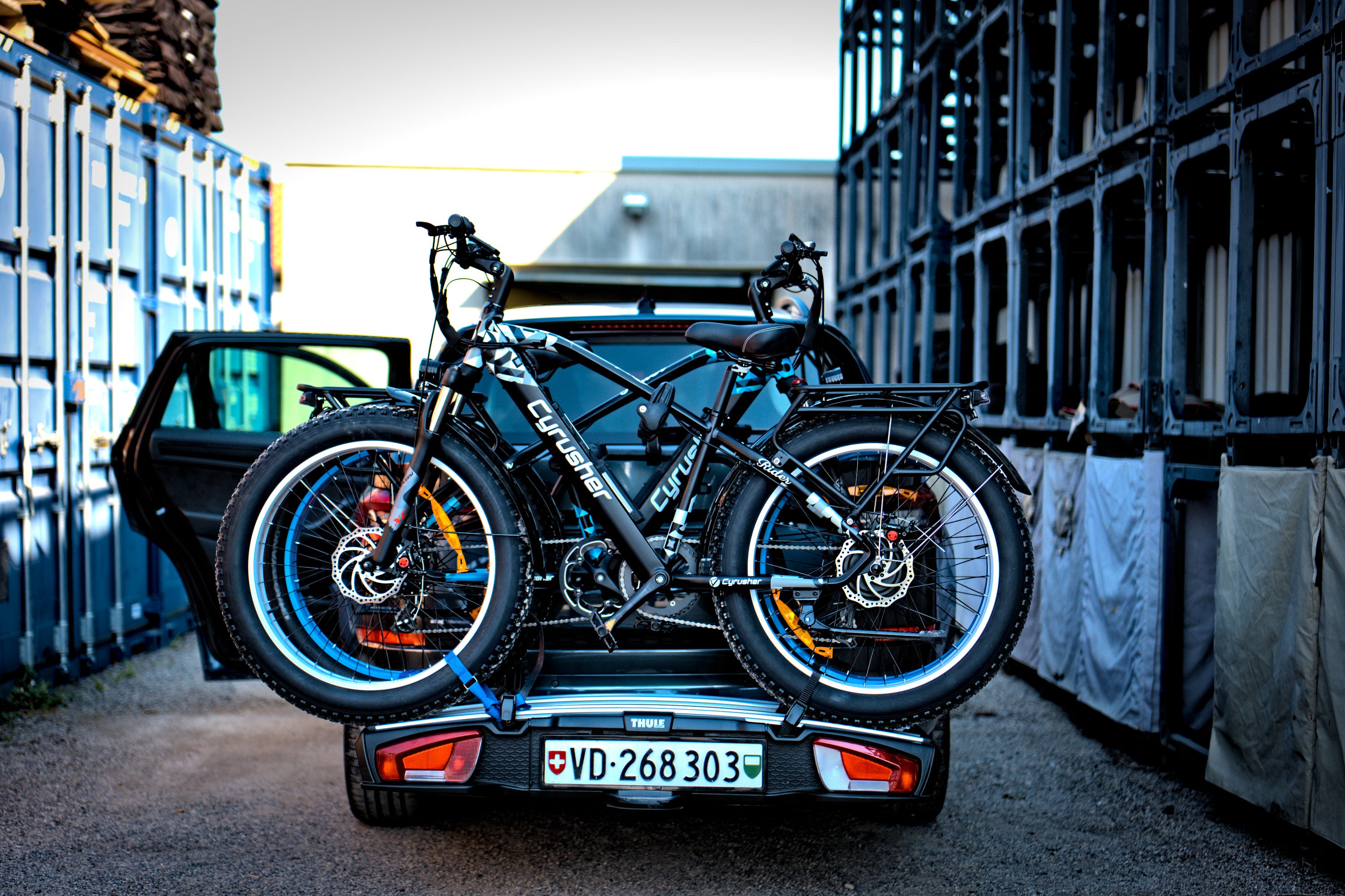 Two electric bicycles hanging from the car