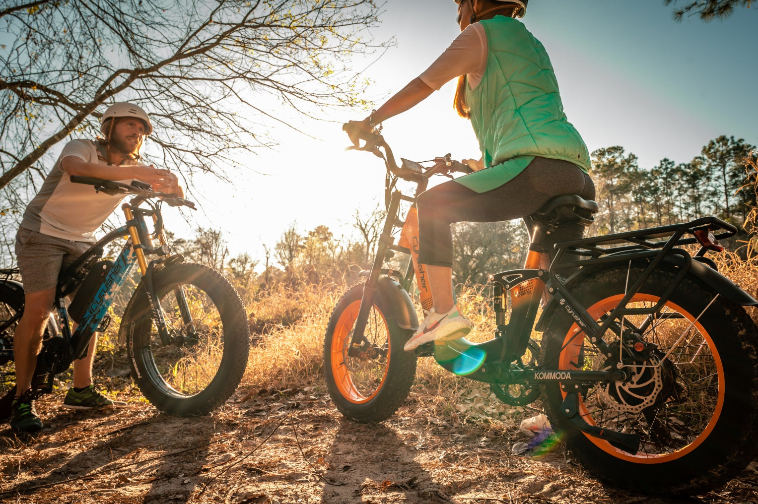 A man and woman riding their electric bikes in the mountain