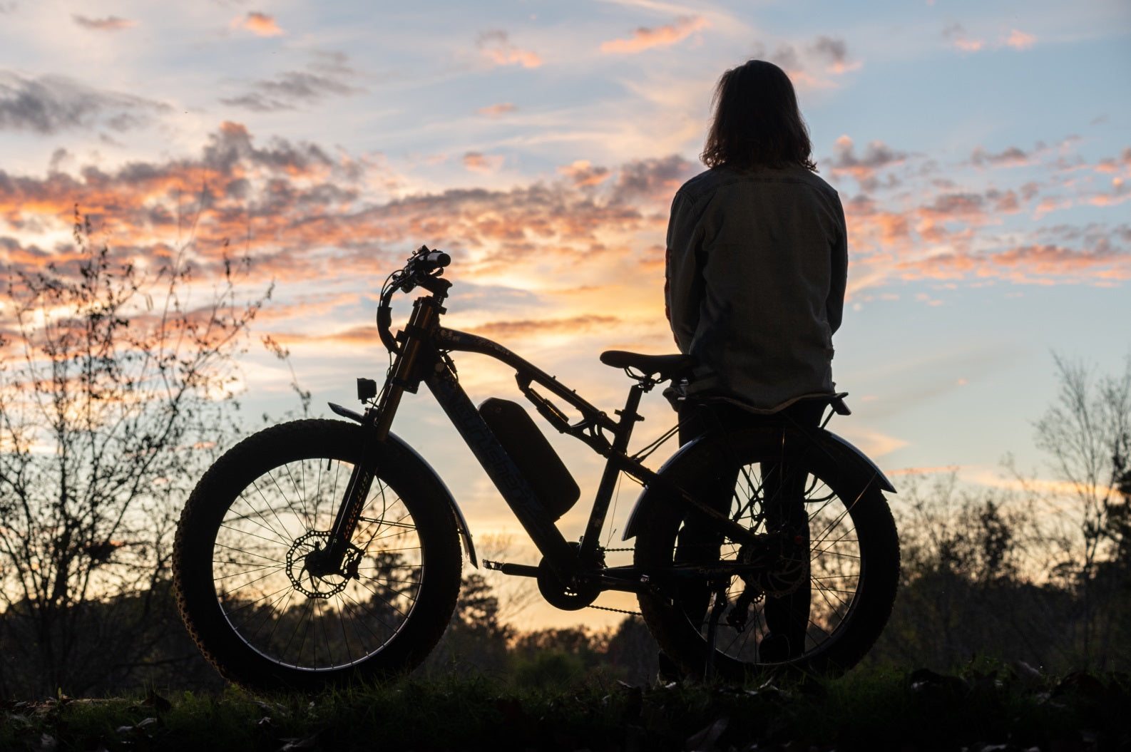 Looking at the scenery at sunset with his e-bike